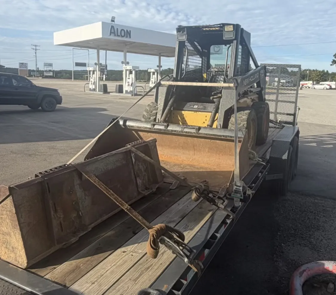 New Holland skid steer loaded behind two landscaping buckets